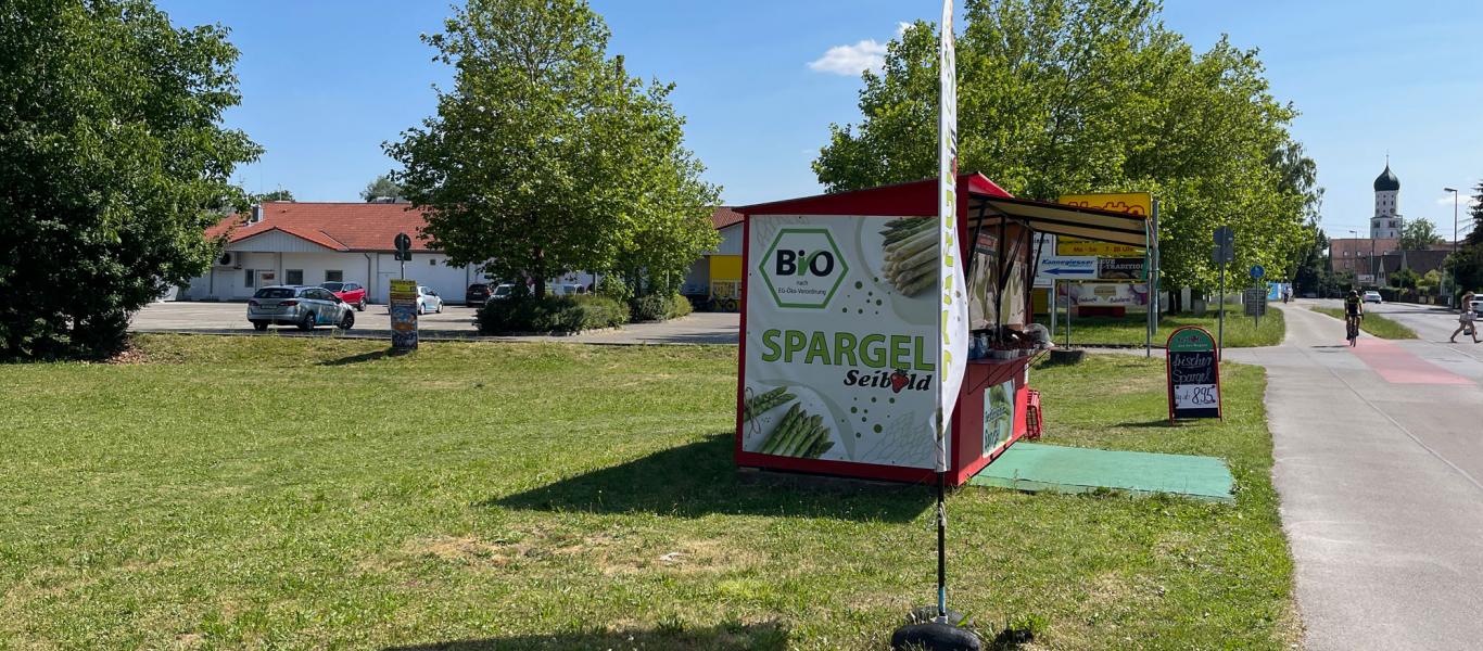 erkaufsstand von Biohof Seibold mit Bio-Spargel-Banner an der Straße in Inningen